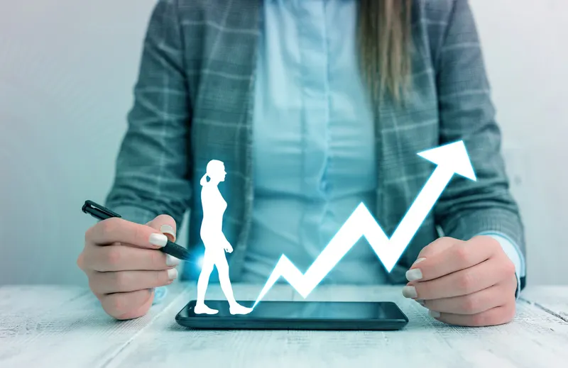 Man with a smartphone and a rising bar graph showing growing annual profits
