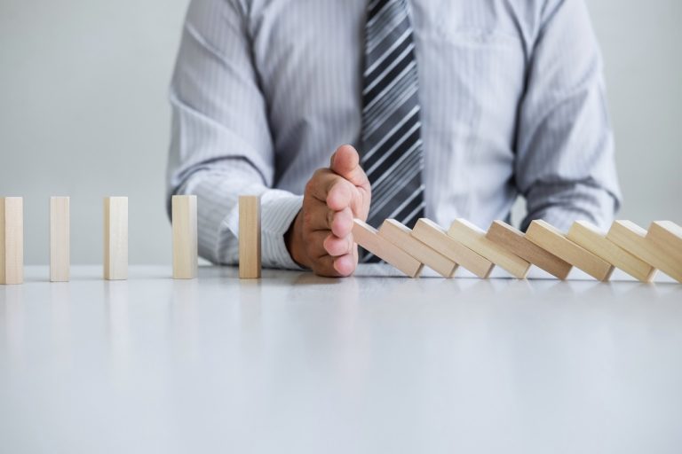 Planning Risk and Strategy in Business, Image of hand Businessman stopping and protection for collapse of wooden block game being falling down dominoes effect problem solving of prevent
